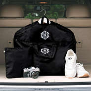 black packable garment bag and duffel in trunk