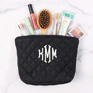 toiletries spilling out of black quilted cosmetic case