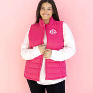 monogrammed hot pink puffer vest in front of pink paper