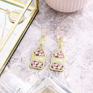 rose all day earrings on marble counter top