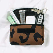 neoprene travel pouch with cosmetics and airpods in hickory leopard