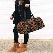 sherpa fuzzy duffel bag in hickory leopard on wrist
