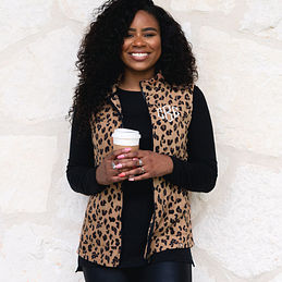 monogrammed leopard vest against stone wall