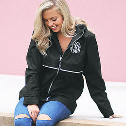 monogrammed black rain jacket in front of pink wall