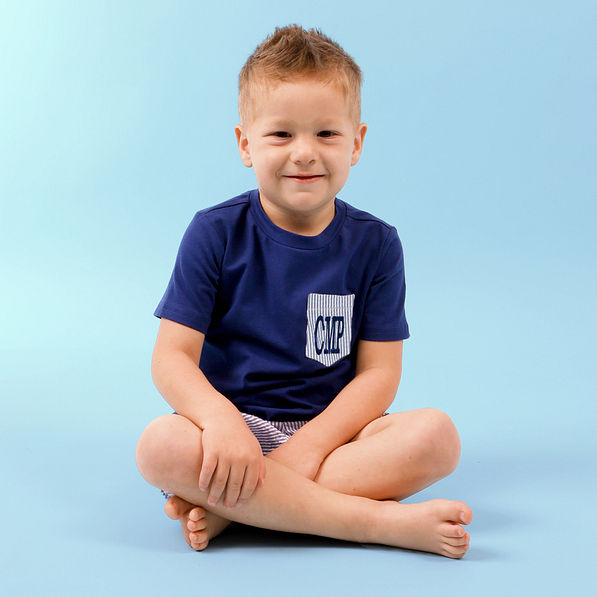boy sitting wearing monogrammed navy outfit