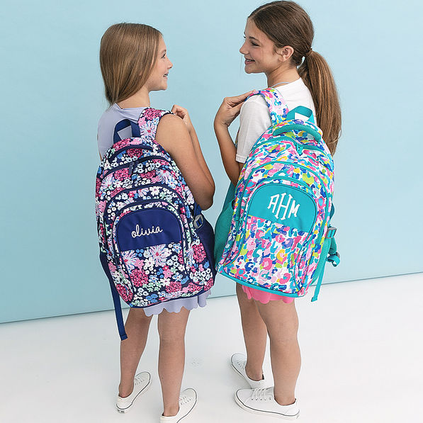 posey petals and watercolor cheetah backpacks on girls shoulders