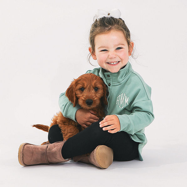 toddler in sage sweatshirt with puppy