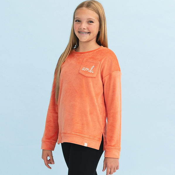 girl wearing pumpkin kids softspun sweatshirt