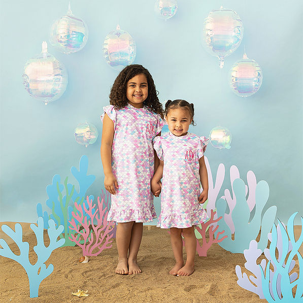 2 girls wearing mermaid nightgown on sea background