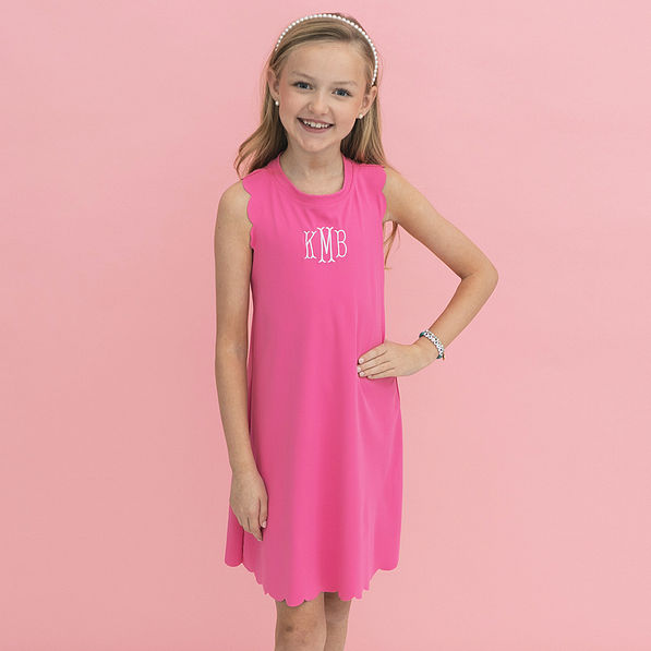 girl wearing monogrammed girls scallop dress in hot pink