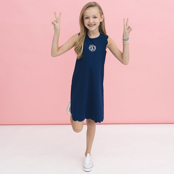 girl wearing monogrammed girls scallop dress in navy