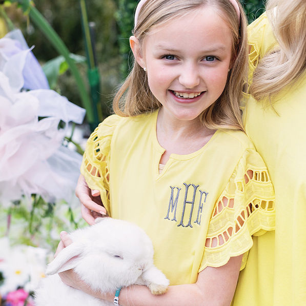 close up of girl wearing monogrammed girls flutter sleeve dress in soft yellow