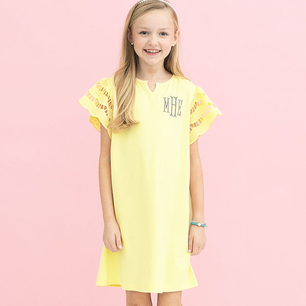 girl wearing monogrammed girls flutter sleeve dress in soft yellow