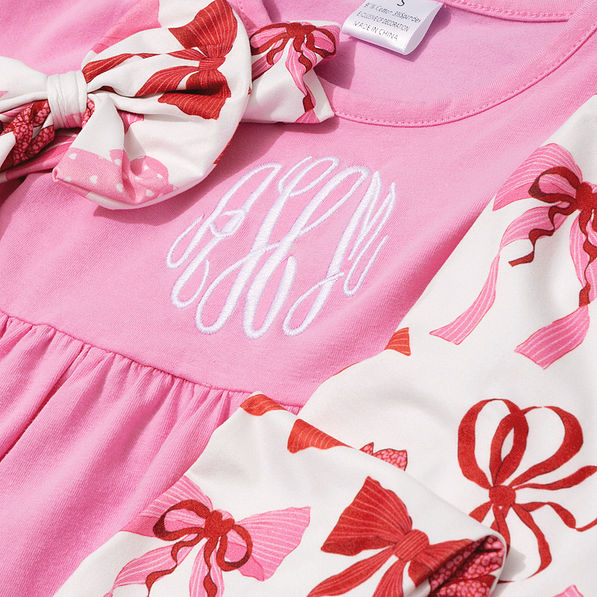 close up of monogrammed girls ruffle tunic legging set with bow in pink bows