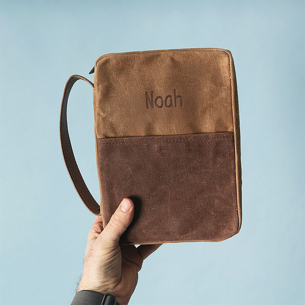 man holding bible carrier in brown