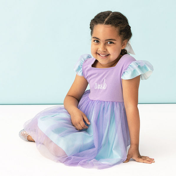 girl sitting in personalized blue and purple twirl dress