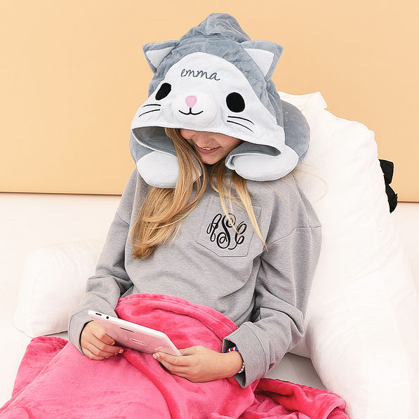 girl wearing monogrammed kitty hooded travel pillow playing games