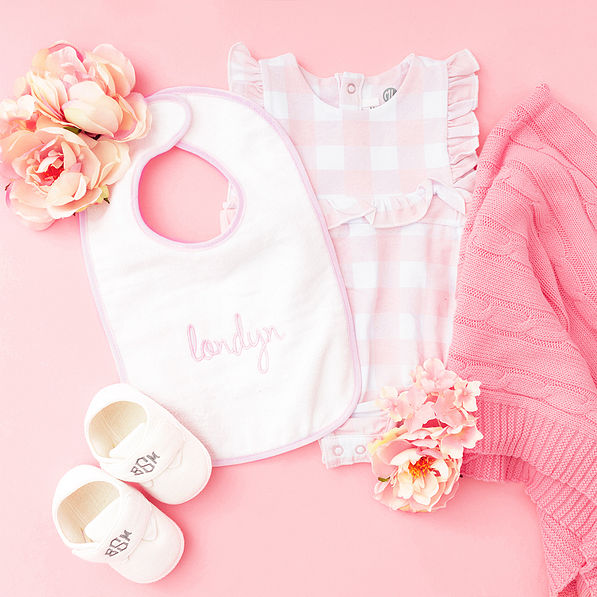 pink outline baby bib flatlay