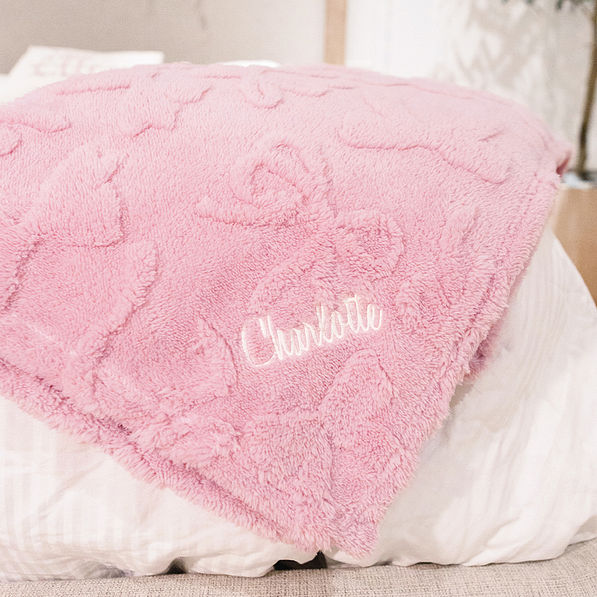 pink kids bow blanket on bed