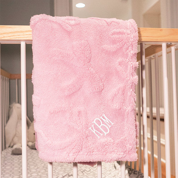 pink baby blanket on crib