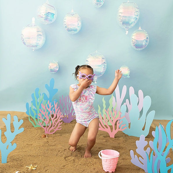 girl wearing ruffle bathing suit in mermaid and swimming goggles