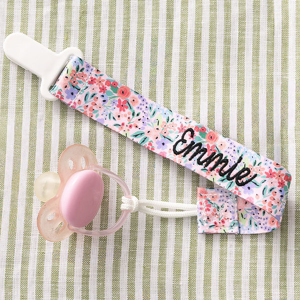 close up of personalized paci clip in coral floral