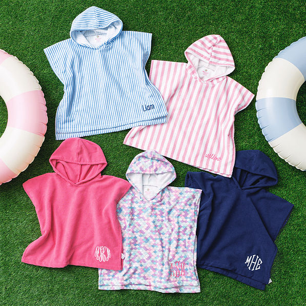 multiple personalized toddler hooded towel ponchos on grass