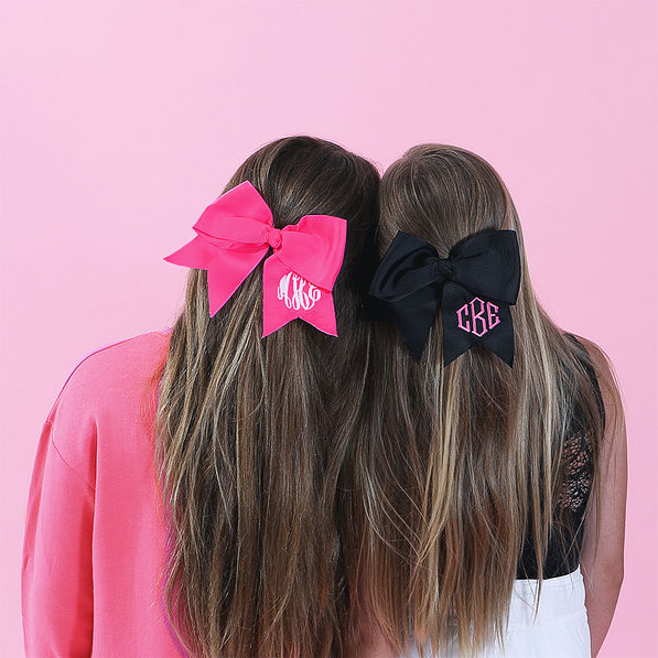 sisters wearing hot pink 2026 and black hair bows