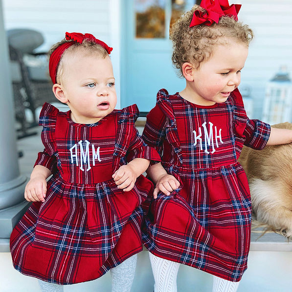 sisters wearing matching holiday plaid dresses