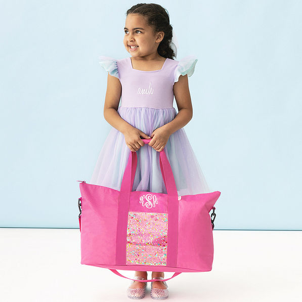girl holding monogrammed pink kids weekend bag