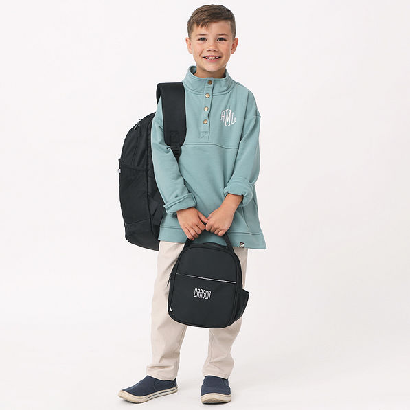 little boy with black monogrammed backpack and lunch box