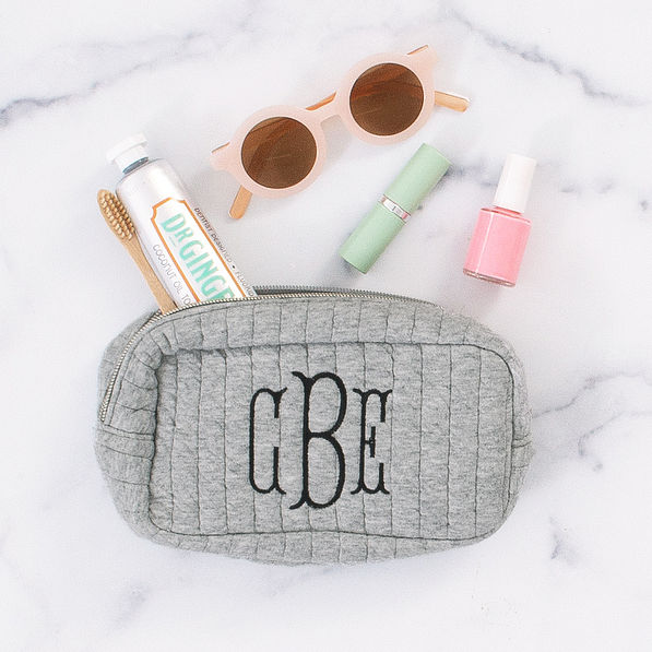 spill shot of gray quilted cosmetic case