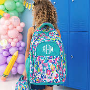 girl carrying watercolor cheetah monogrammed backpack and lunch box