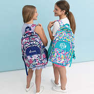 posey petals and watercolor cheetah backpacks on girls shoulders