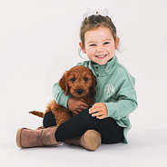 toddler in sage sweatshirt with puppy