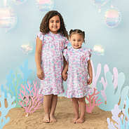 2 girls wearing mermaid nightgown on sea background