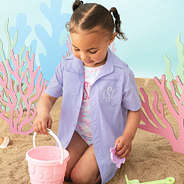 girl building sand castle with monogrammed lavender fishing shirt