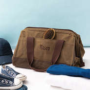 dark brown waxed canvas overnight bag with blue background