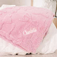 pink kids bow blanket on bed