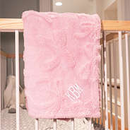 pink baby blanket on crib