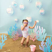 girl wearing ruffle bathing suit in mermaid and swimming goggles