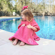 girl wearing hot pink toddler hooded swim poncho cover up