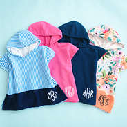 group of toddler hooded towel ponchos on blue background