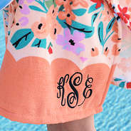 close up of coral floral monogrammed toddler hooded poncho