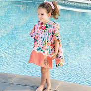 girl wearing monogrammed toddler hooded poncho in coral floral