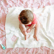 baby girl sitting on ivory personalized blanket