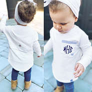 baby in white monogrammed top