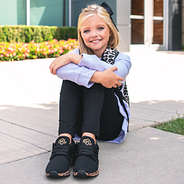 little girl with leopard backpack and leopard shoes