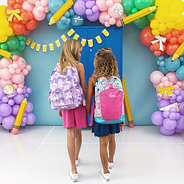 2 girls in flower power and unicorn backpacks