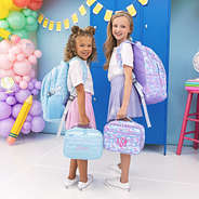 two girls carrying matching personalized backpacks and lunch boxes in mermaid magic and blue quilted hearts